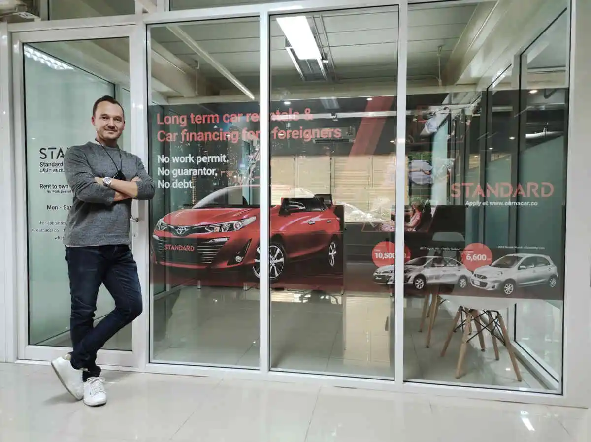 Jaun-Paul Stevenson standing in front of Standard Car Rental Co., Ltd Office